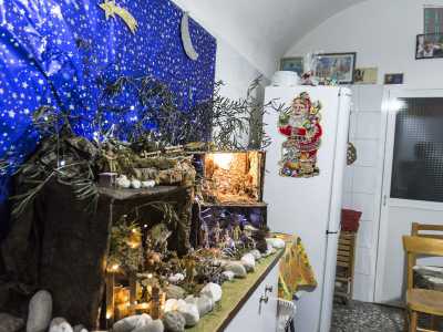 Durante la chiacchierata adocchiamo l'immancabile rappresentazione della nativit�, eseguita usando come sfondo un vistoso foglio blu stellato e dei ramocelli di ulivo a coprire la mangiatoia del Messia